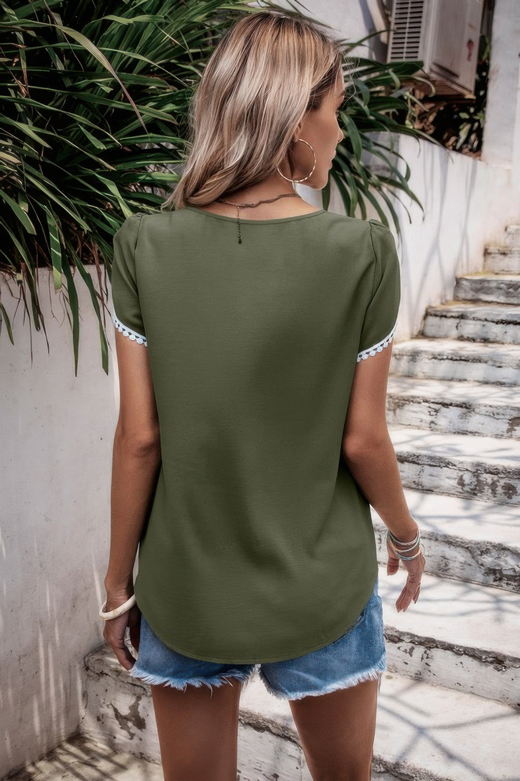Olive round neck top with flutter sleeves and white trim, back view