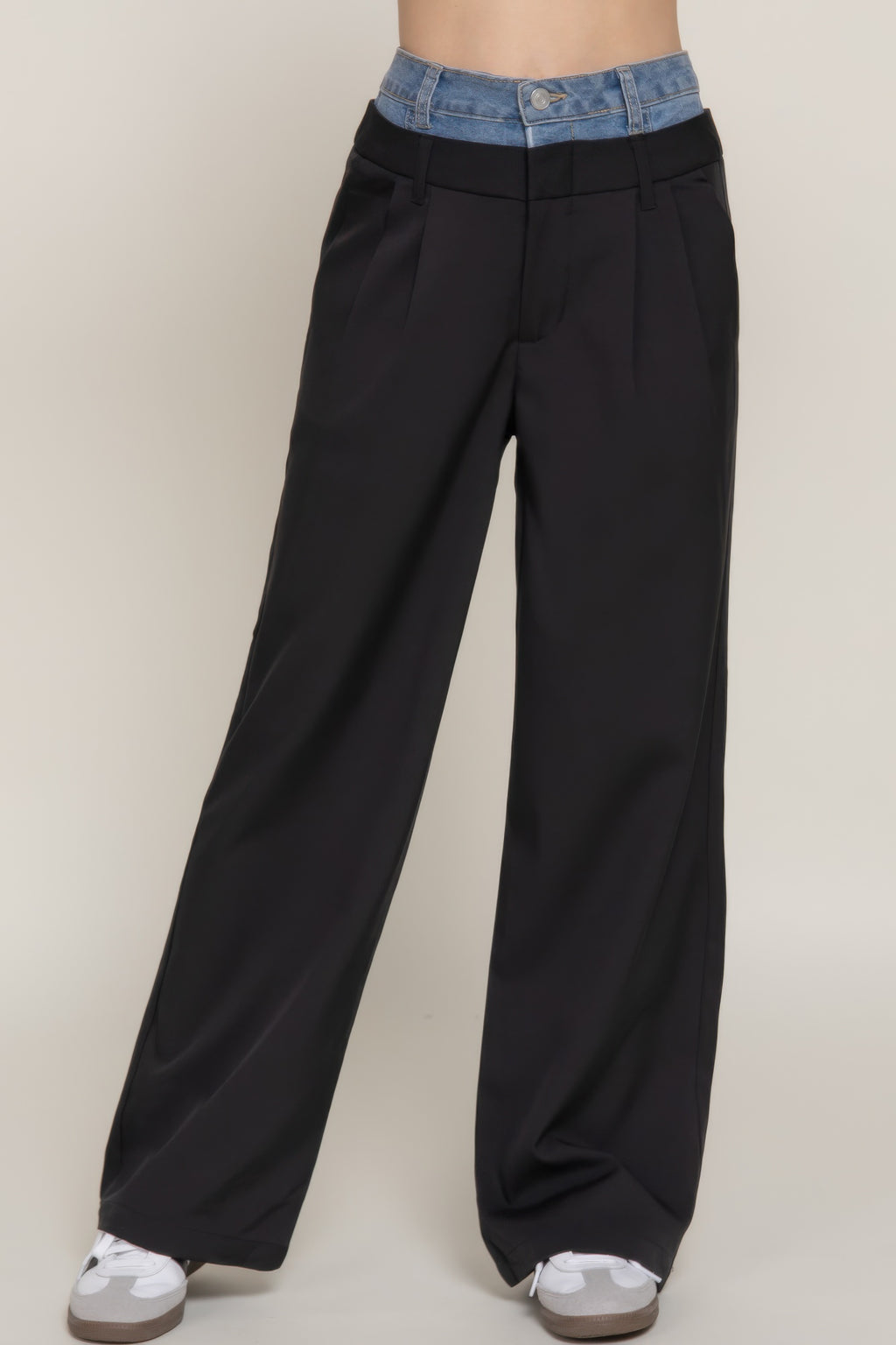 Black straight long pants close-up: blue denim waistband, pleats, front pockets