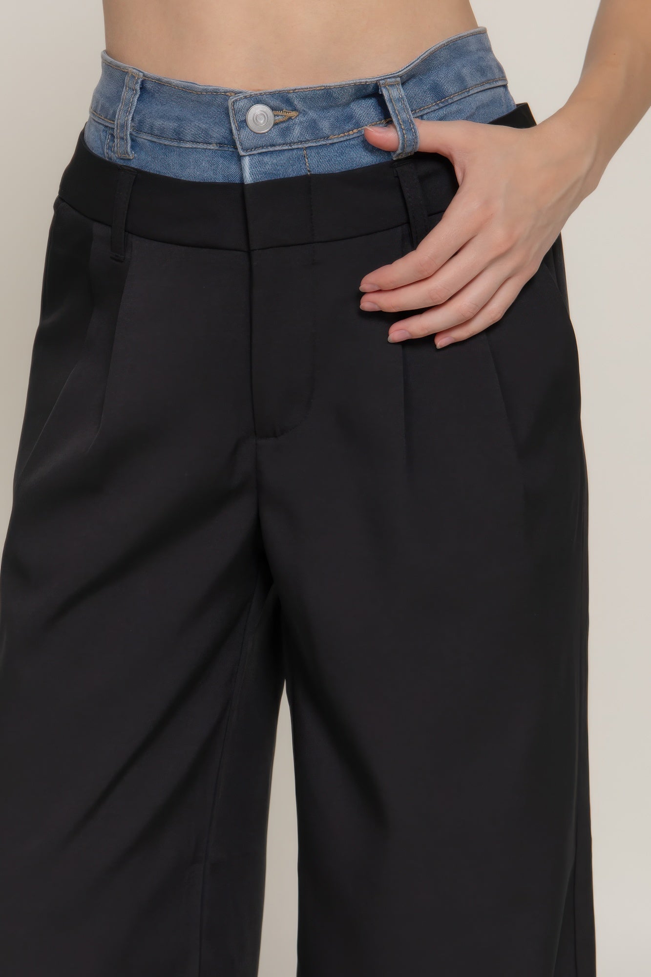 Black pants detail: blue contrast denim waistband with button and belt loops