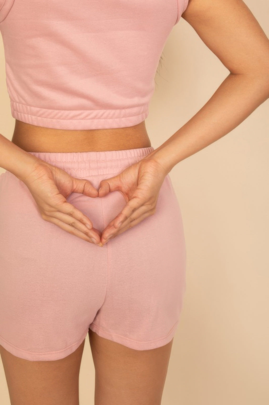 Dusty pink shorts detail: elastic waistband and drawstring front, with crop top hem