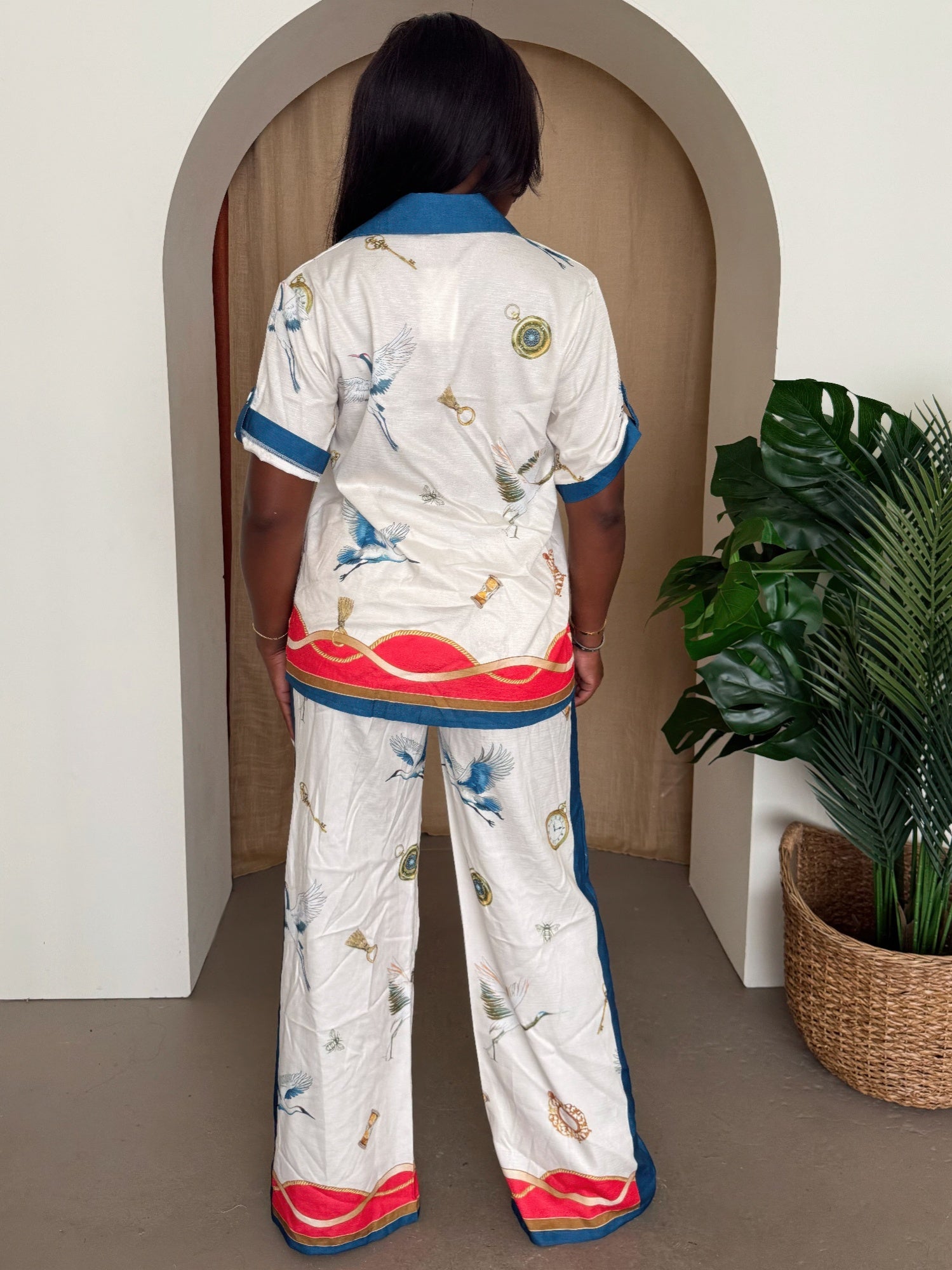 Back view of ivory nautical print short-sleeve shirt and wide-leg pants set with blue collar