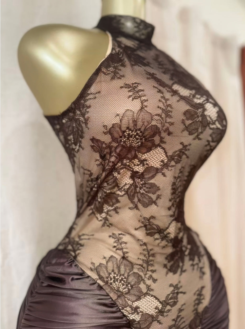 Close-up lace bodice of hourglass dress with floral pattern over draped ruched midsection