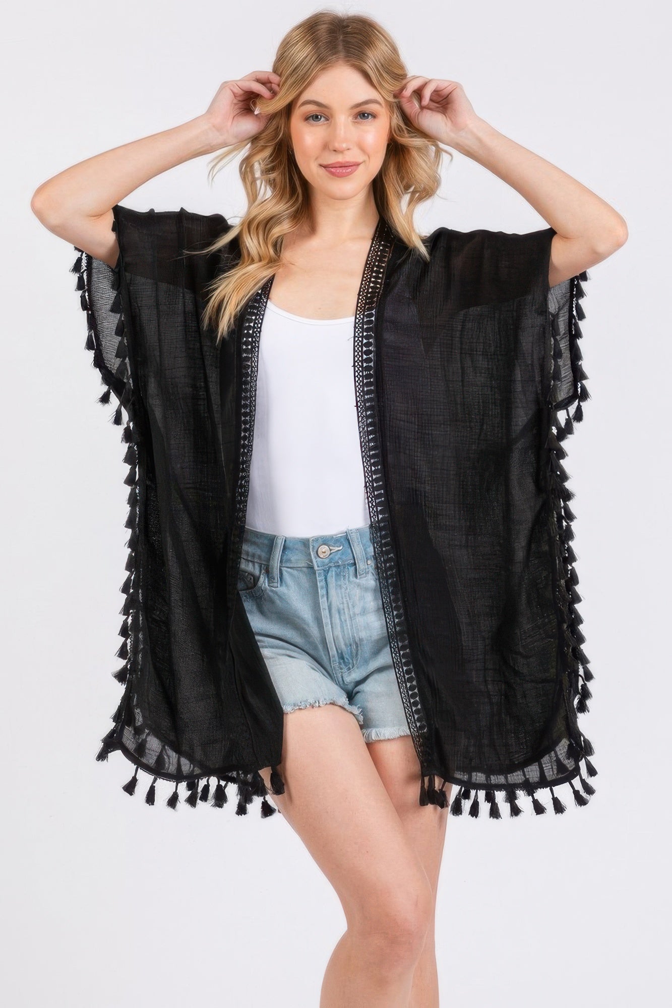 Black poncho-style cover-up with vertical crochet border and tassel edges
