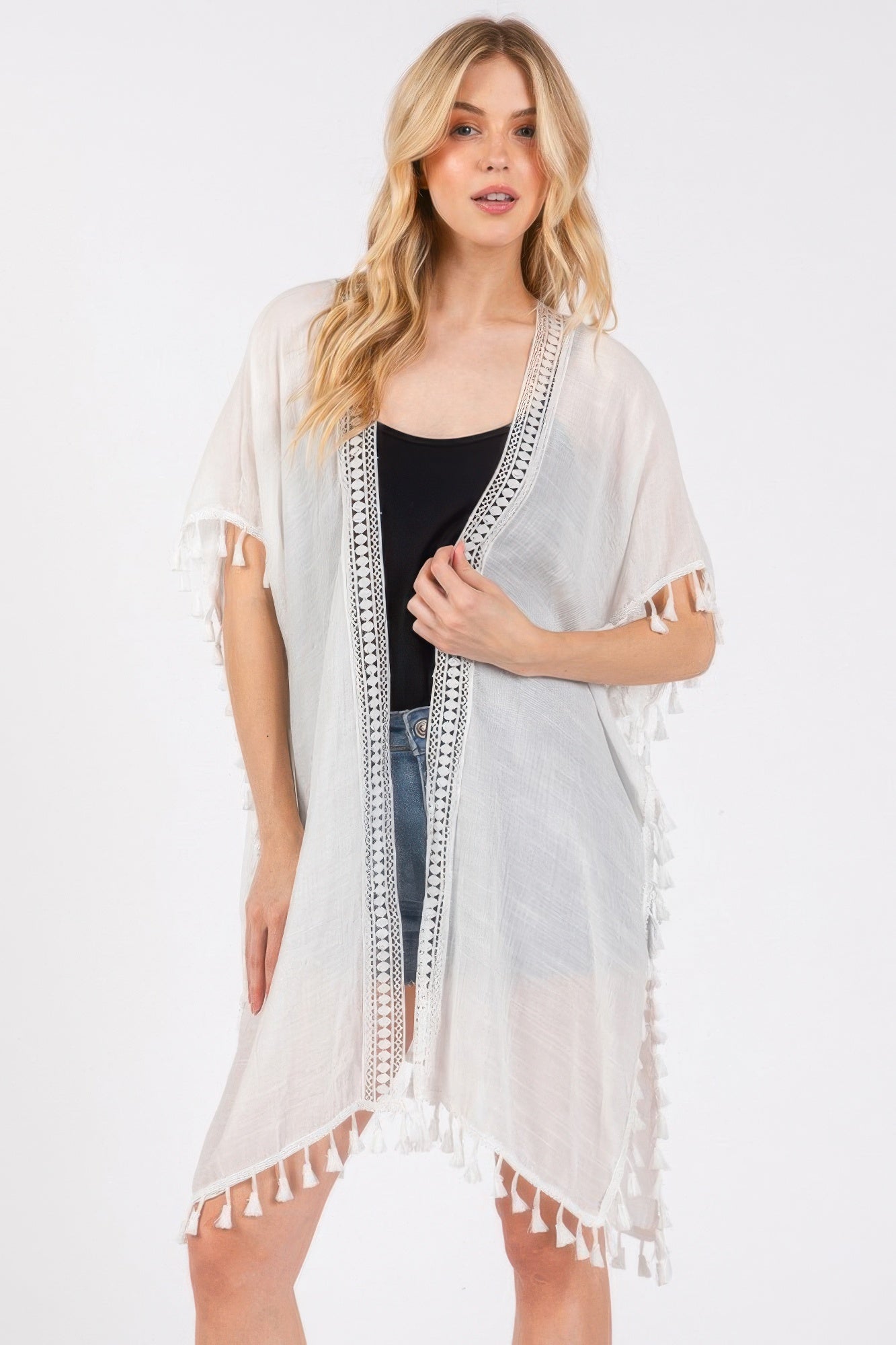White cover-up with open front, crochet trim panel, and tassel fringe