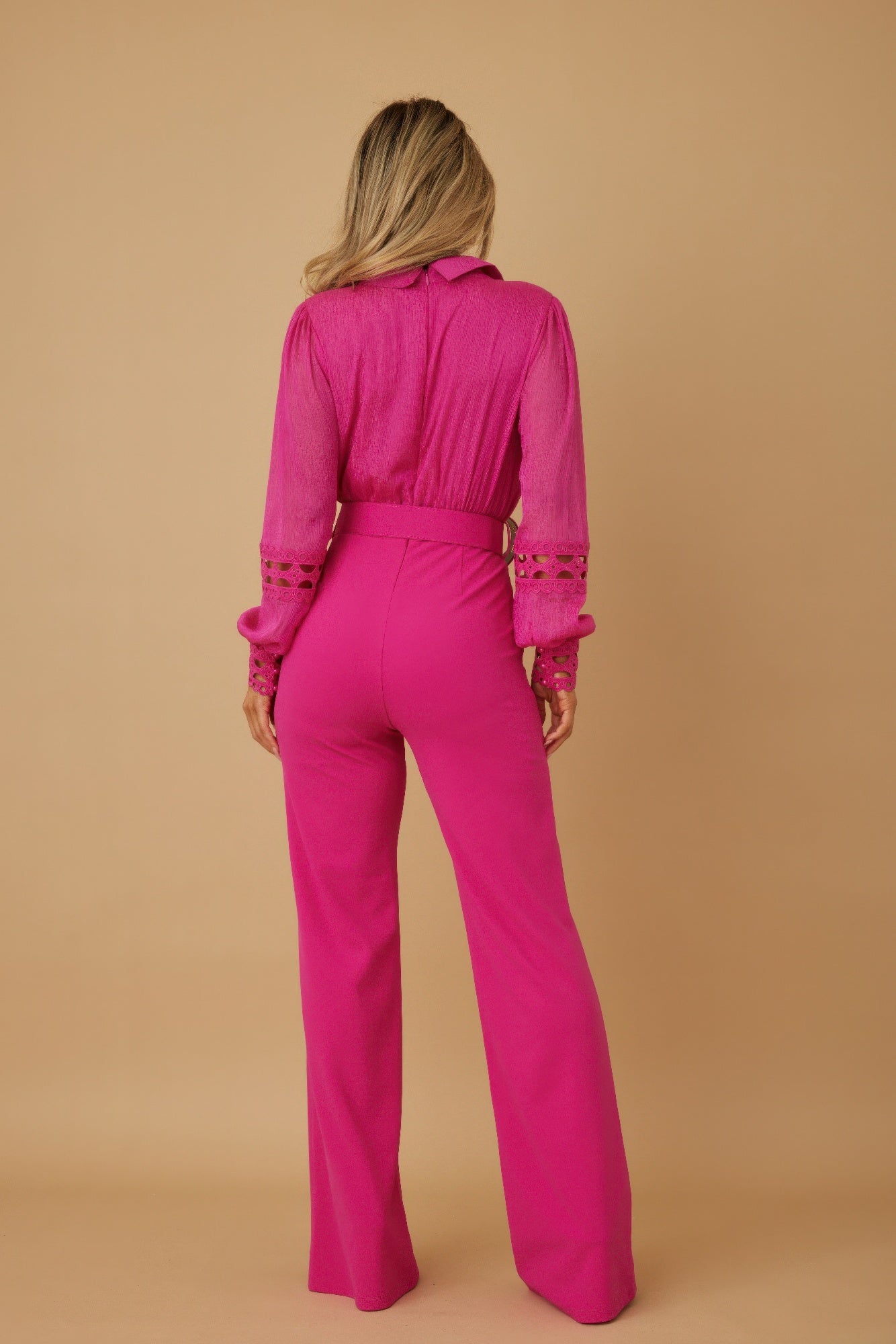 Fuchsia jumpsuit back view with crochet sleeve cuffs and wide-leg silhouette