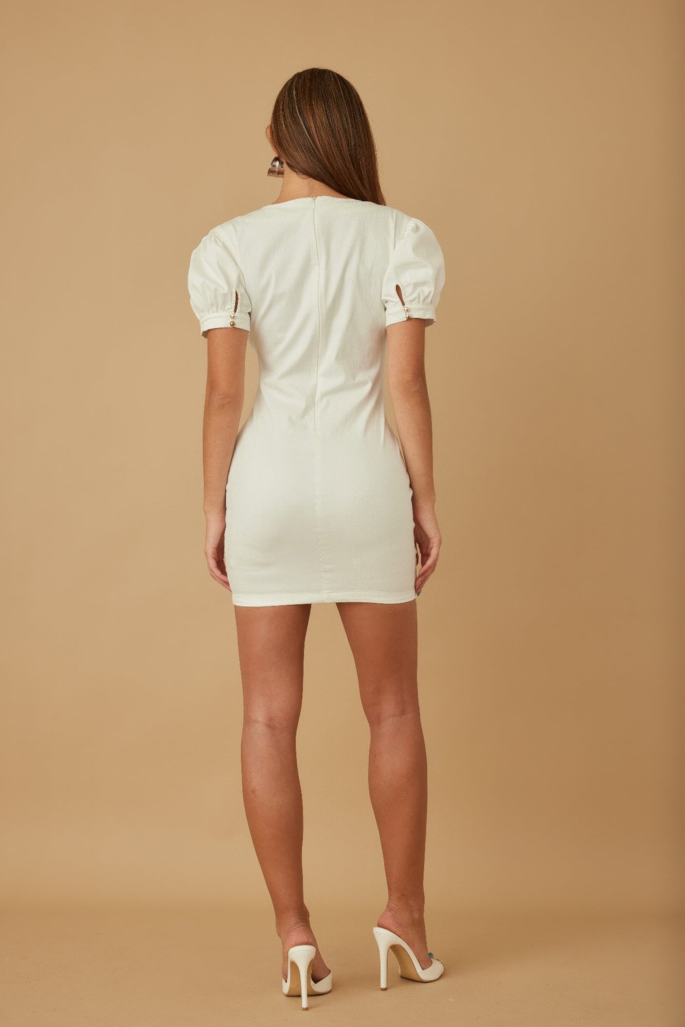Back view of white short button-up dress with puff sleeves and gathered skirt seams