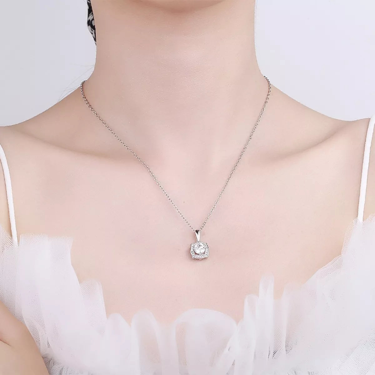 Silver moissanite-style pendant necklace worn at the collar with square halo detail