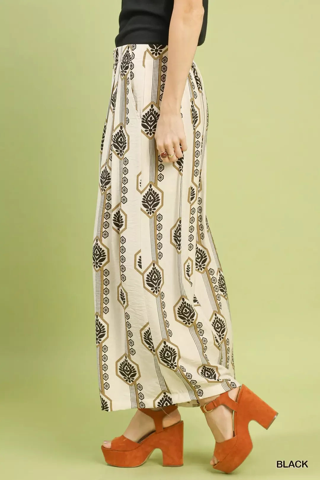 Wide-leg pants, side view: cream fabric with vertical geometric/ornament print, elastic waist