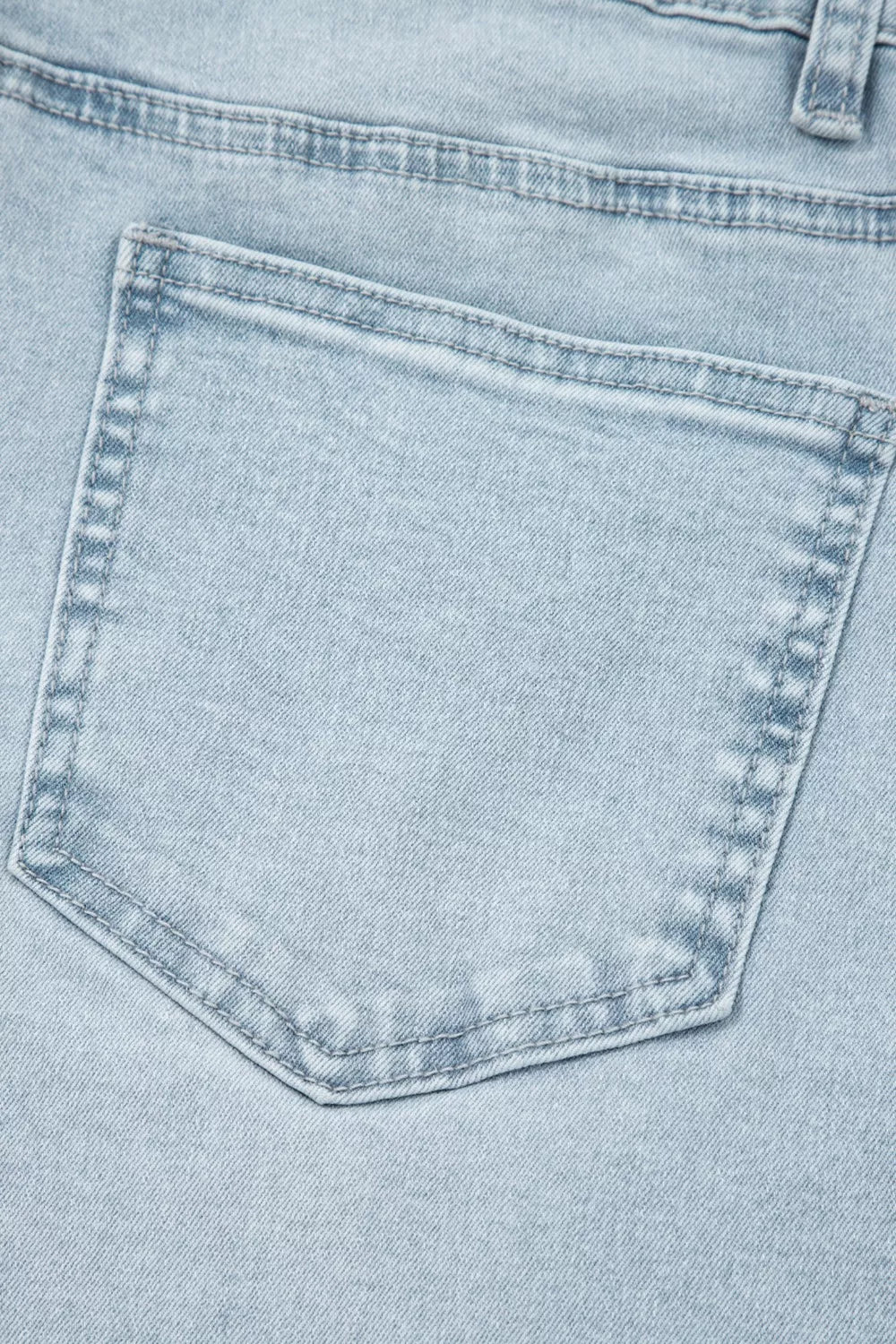 Front utility pocket on light wash straight-leg jeans, light blue denim with stitching
