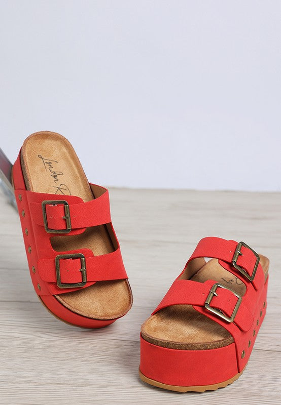Red faux leather flatform sandals with two buckle straps and stud embellishments