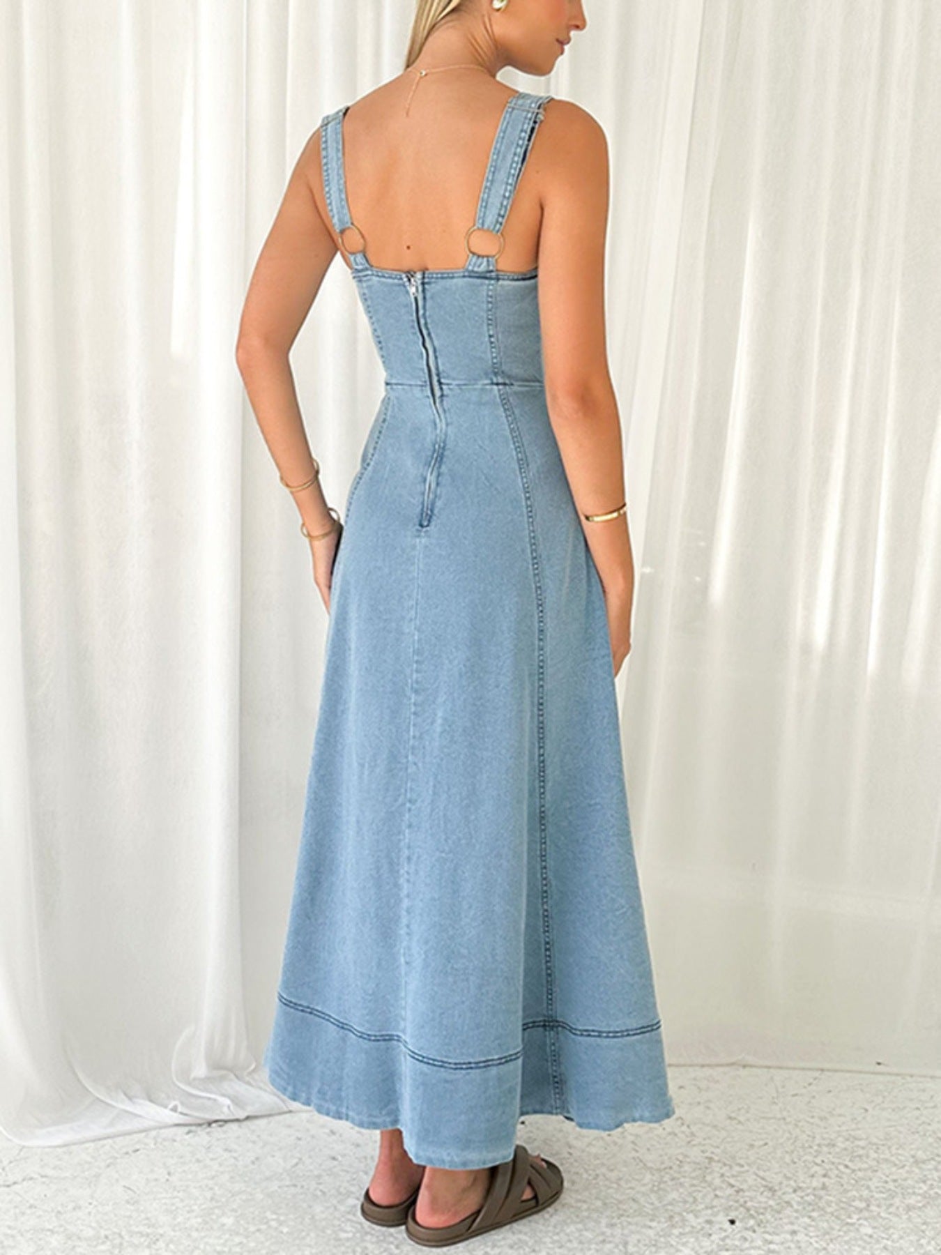 Light blue denim A-line dress back view with button front and sleeveless square back