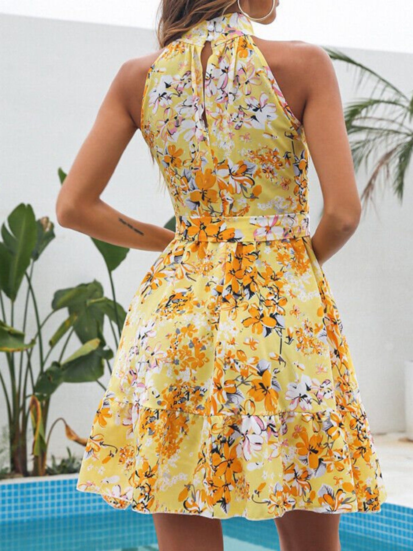 Pastel yellow floral halter mini dress with keyhole neck tie and tiered hem