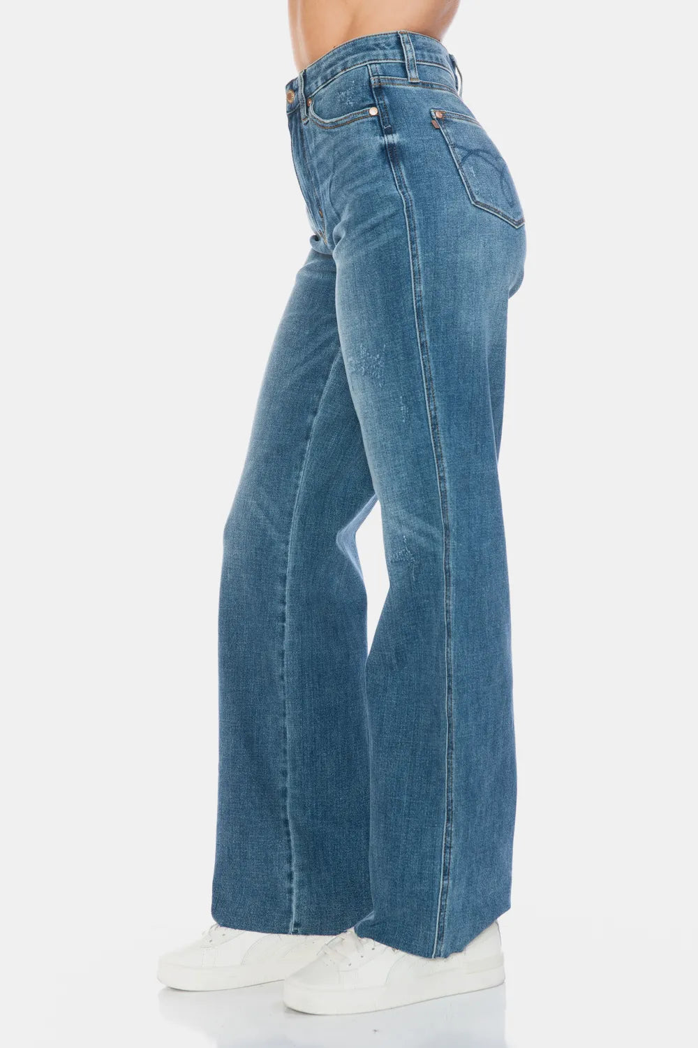 Medium-wash straight jeans side view with raw hem and front belt loops