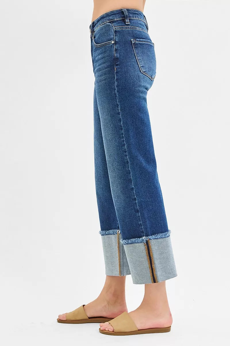 Dark blue side view of mid-rise wide-leg crop jeans with cuffed hem and stitch seams