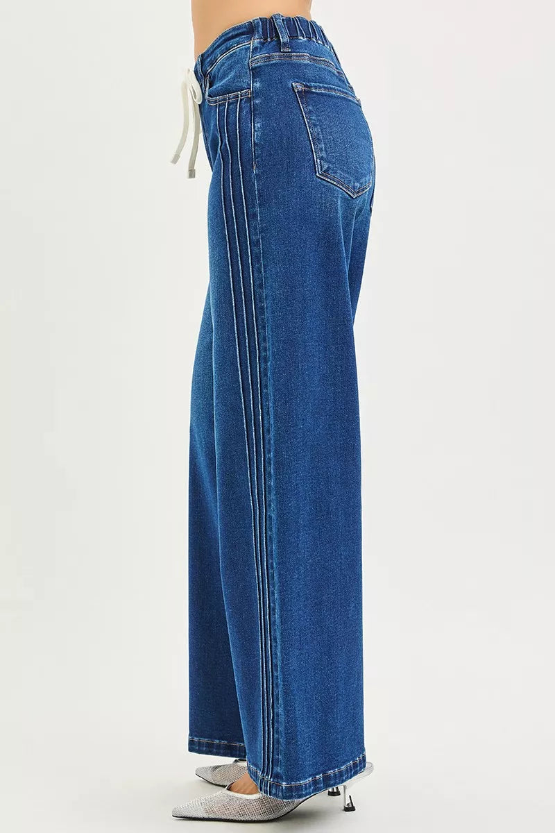 Blue wide-leg jeans, side view, front drawstring tie and front seams