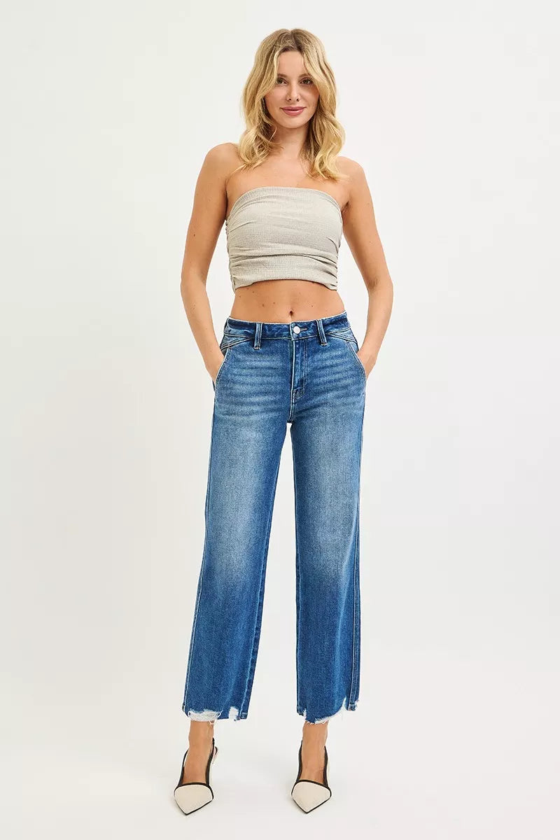High-rise straight blue jeans worn on the waist with frayed ankle hem