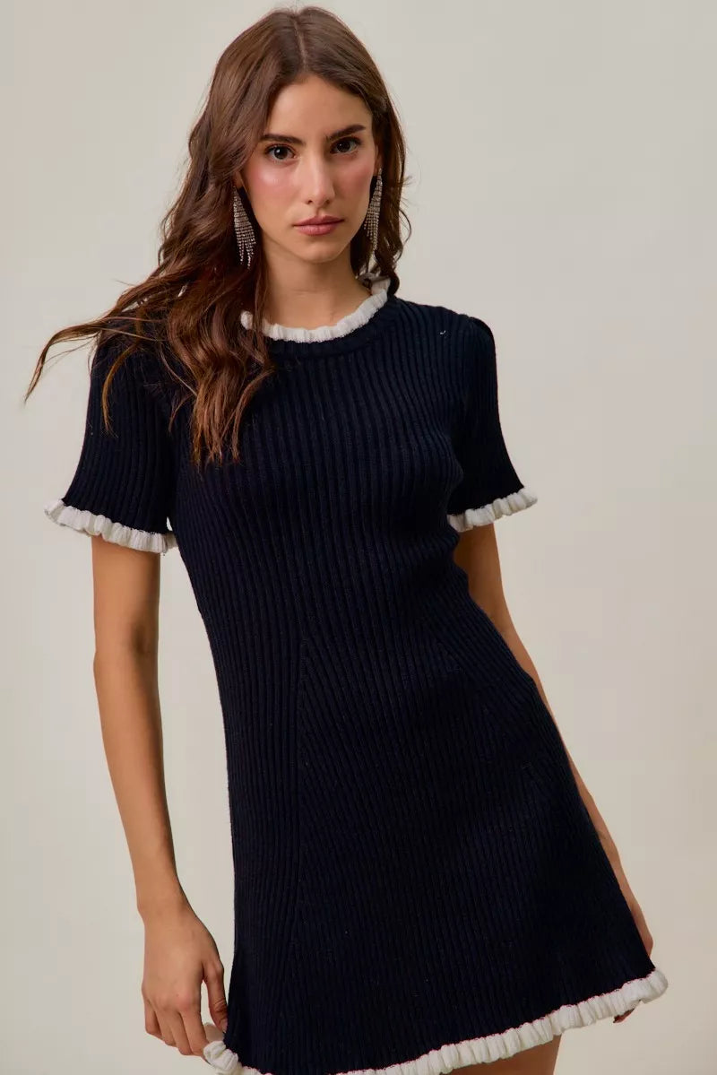 Black ribbed knit mini dress with white ruffle hem and neckline trim, short sleeves