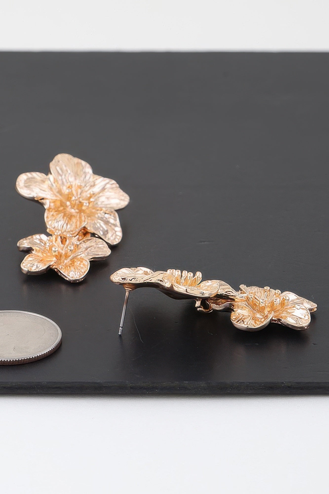 Gold floral cluster earrings with two blooming flowers on curved metal bar