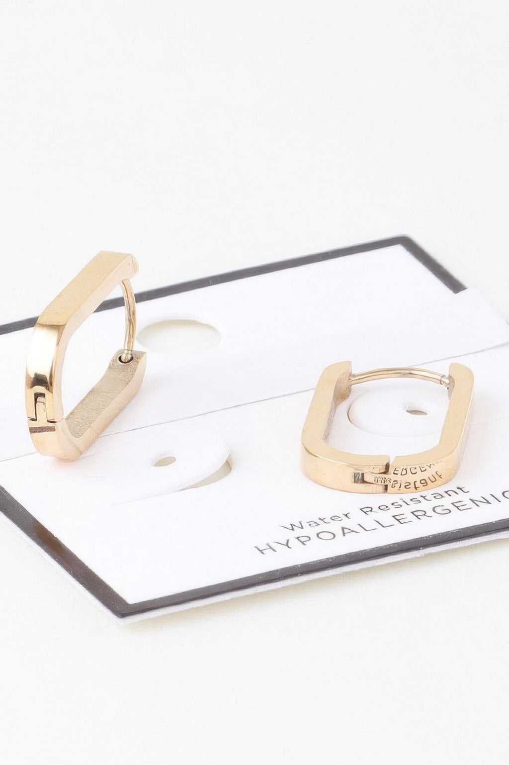Gold-tone oval link hoop earrings with small hinge and open oval frame
