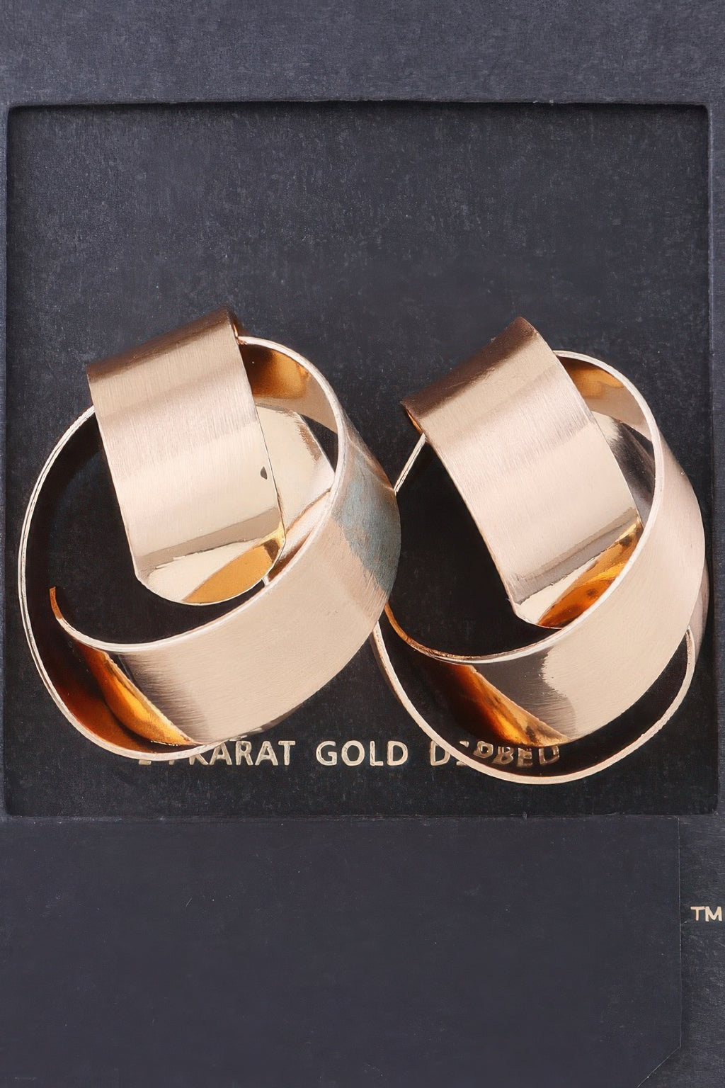 Curved shiny gold hoop earrings, brushed metal finish, open oval shape