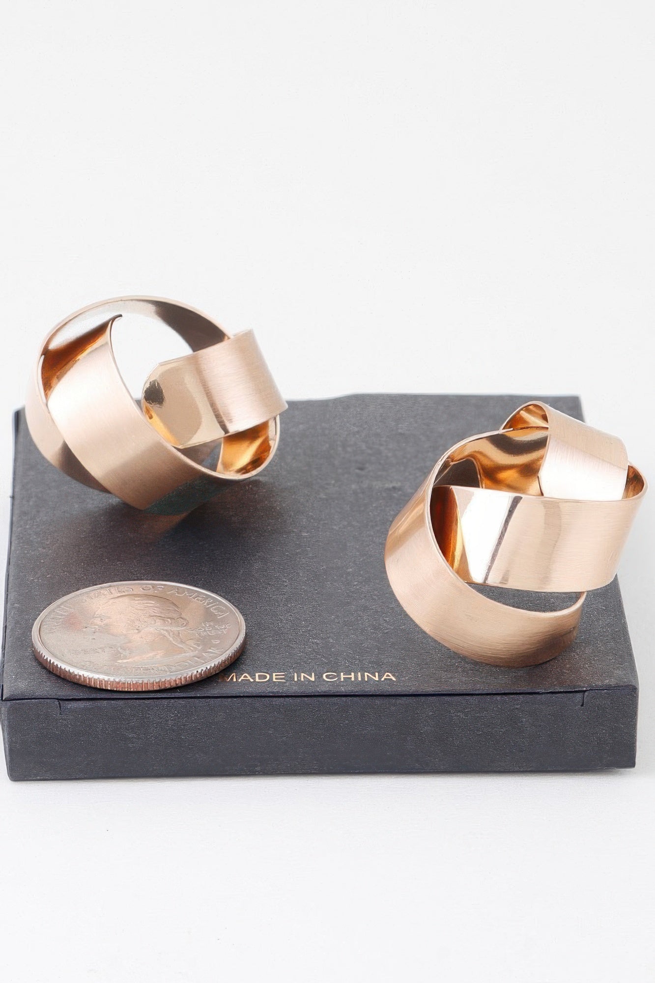 Gold curved hoop earrings with open center, smooth reflective interior