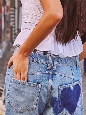 Light-wash denim jeans with dark blue heart patches, front pockets