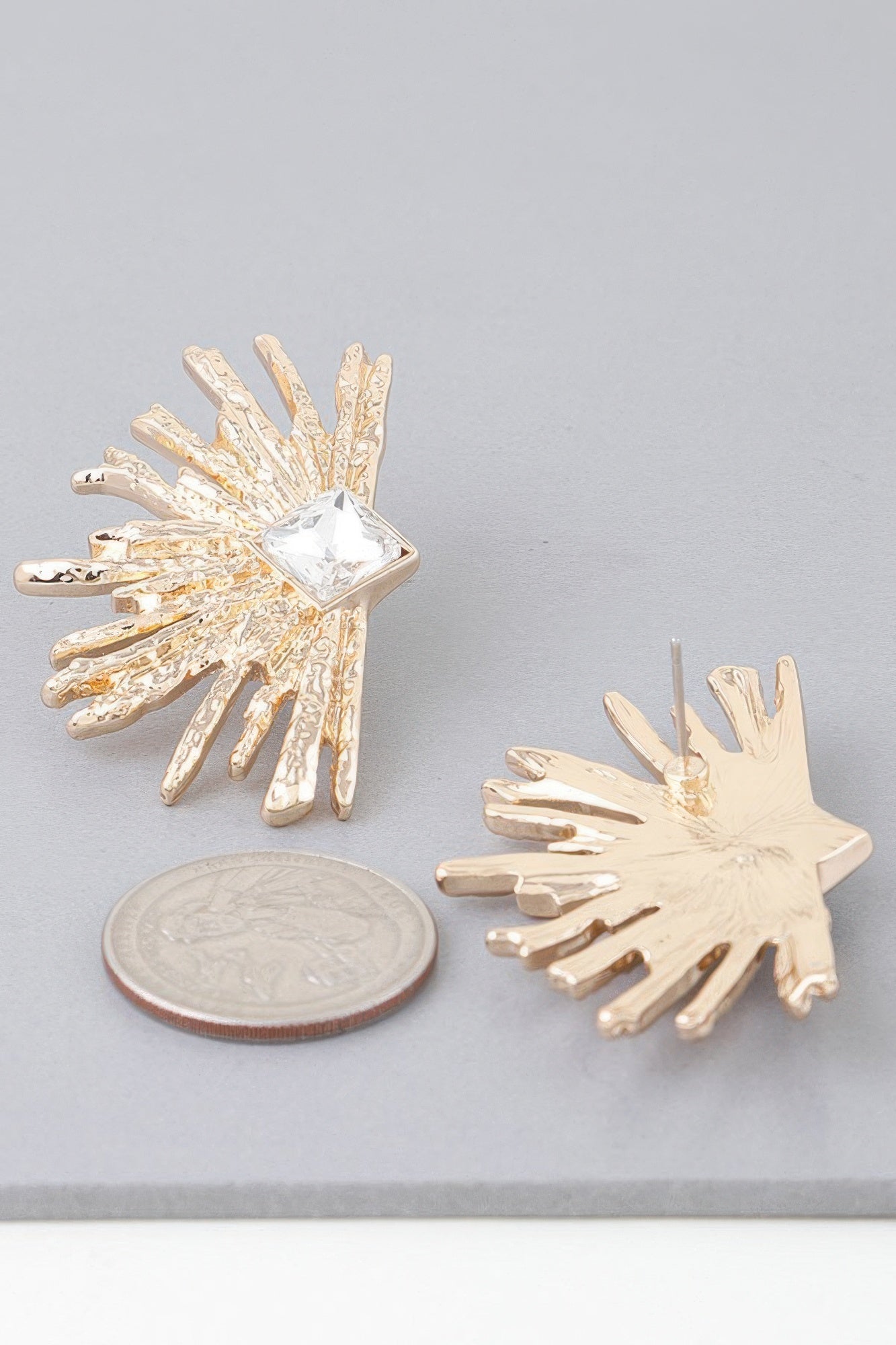 Gold-tone diamond rhinestone flare earrings with clear center stone and long spikes