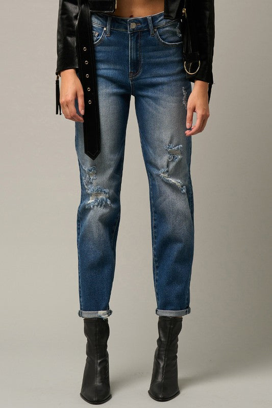 Medium blue distressed girlfriend jeans with thigh and knee rips, rolled ankle hem.
