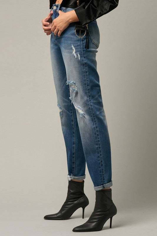 Light-medium blue girlfriend jeans with large knee rip and cuffed ankle hem.