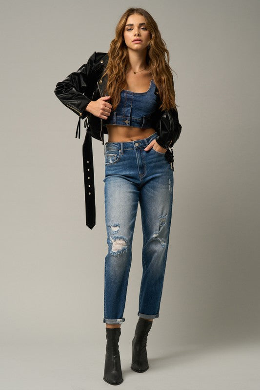 Distressed girlfriend jeans in dark blue with knee rips and rolled ankle cuffs.