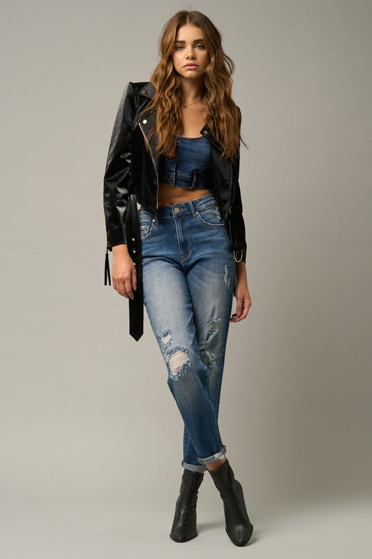 Distressed blue girlfriend jeans with thigh and knee rips and cuffed hem.