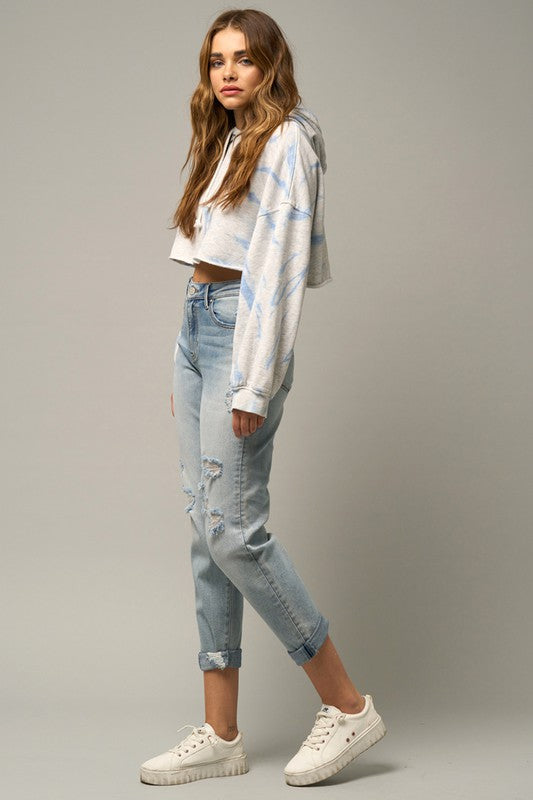 Medium wash distressed girlfriend jeans, cropped length, knee rips on both legs