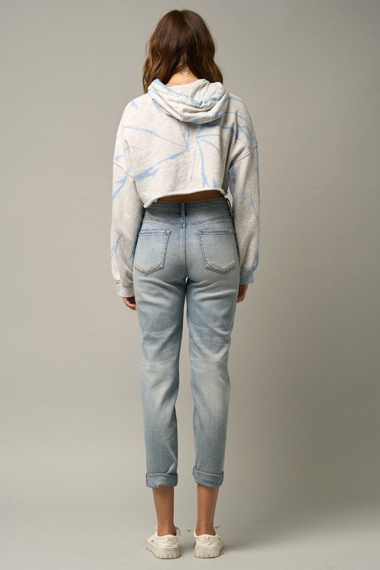 Back view: medium wash distressed girlfriend jeans with two back pockets and cuffed hem