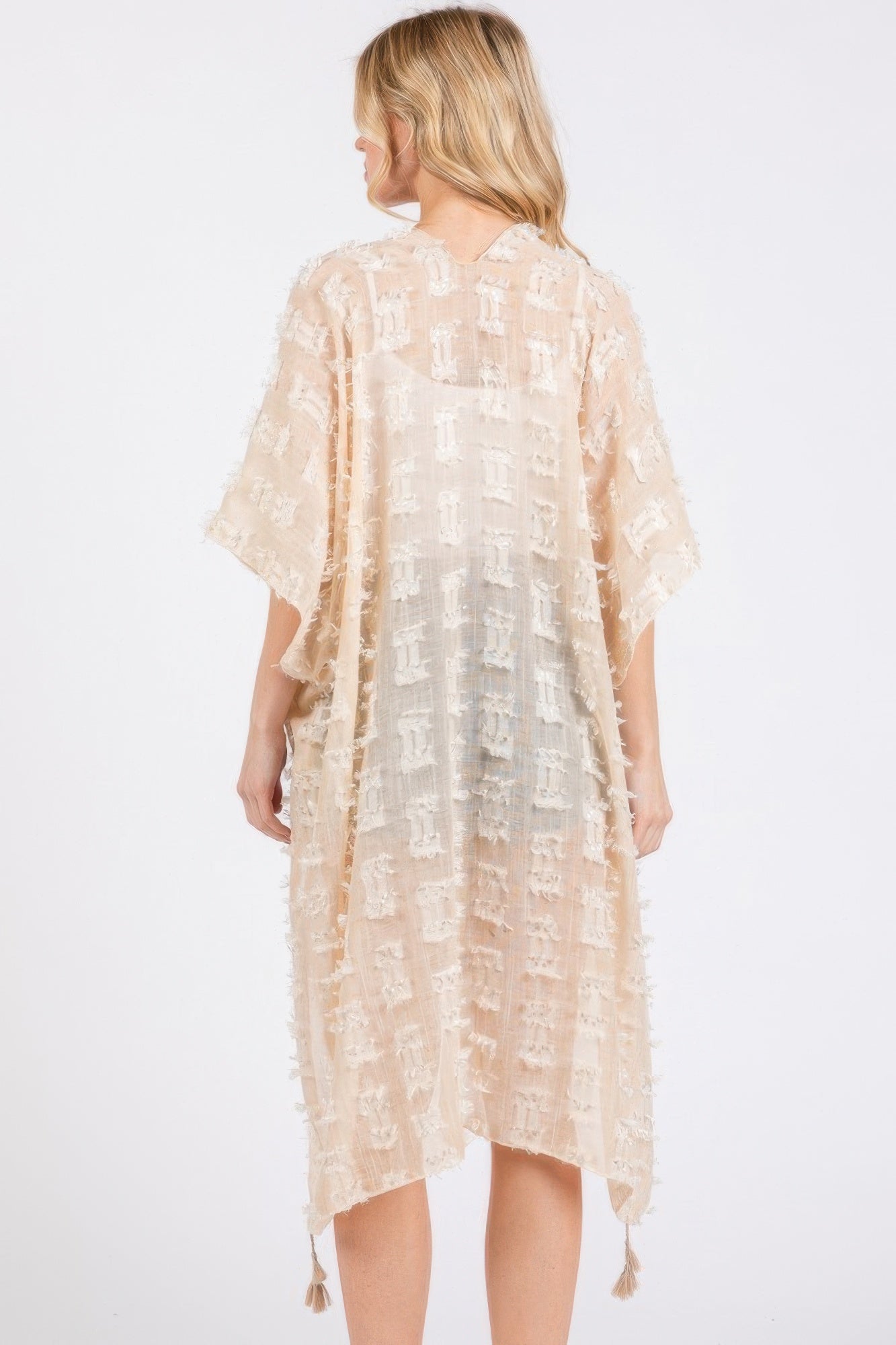 Beige distressed pattern kimono back view with flowing length and tassel trim