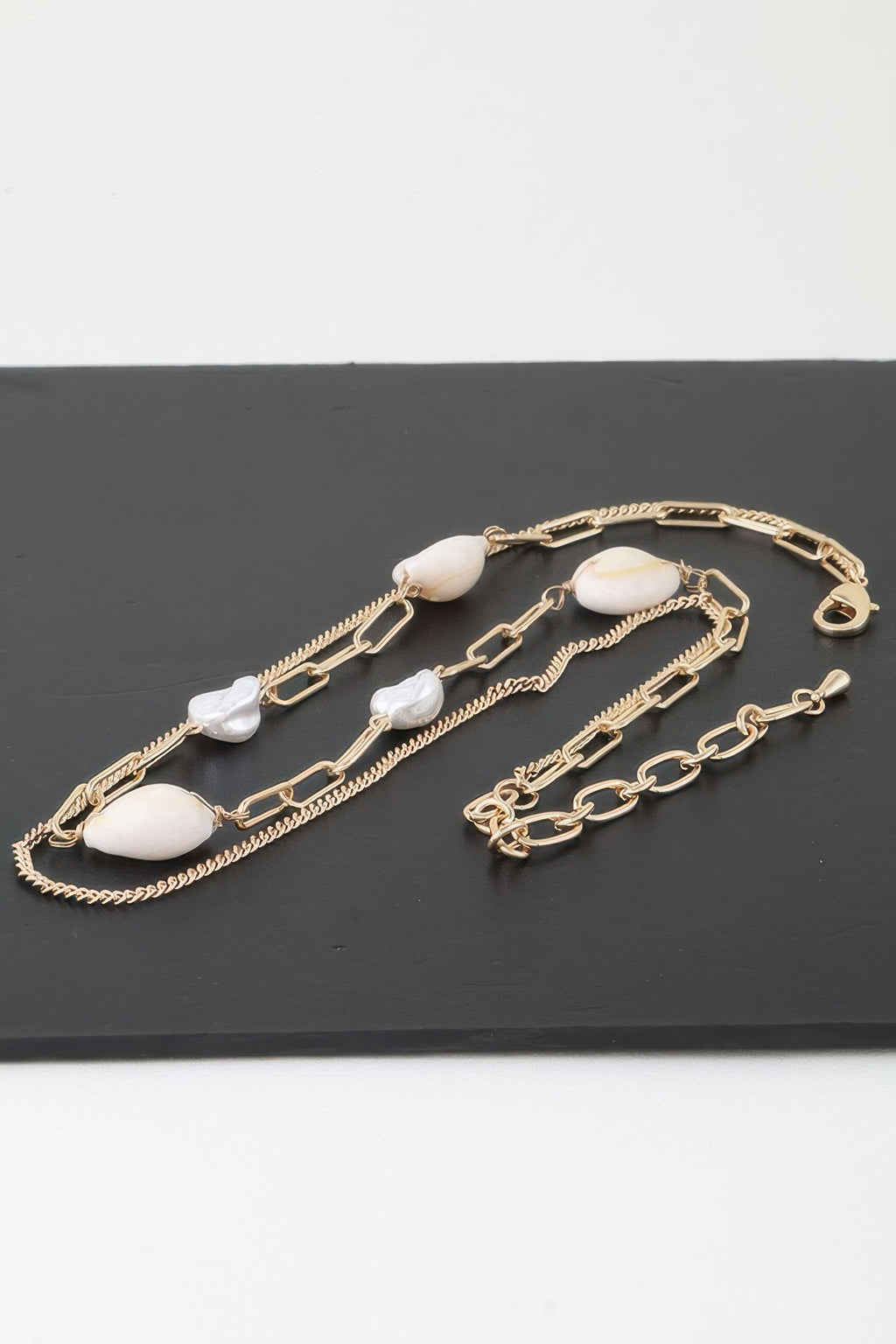Gold-tone double strand necklace with cream oval beads and white pearl accents