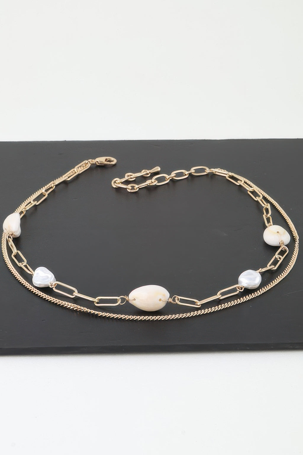 Gold double pearl chain necklace with oval cream pendants and small white beads