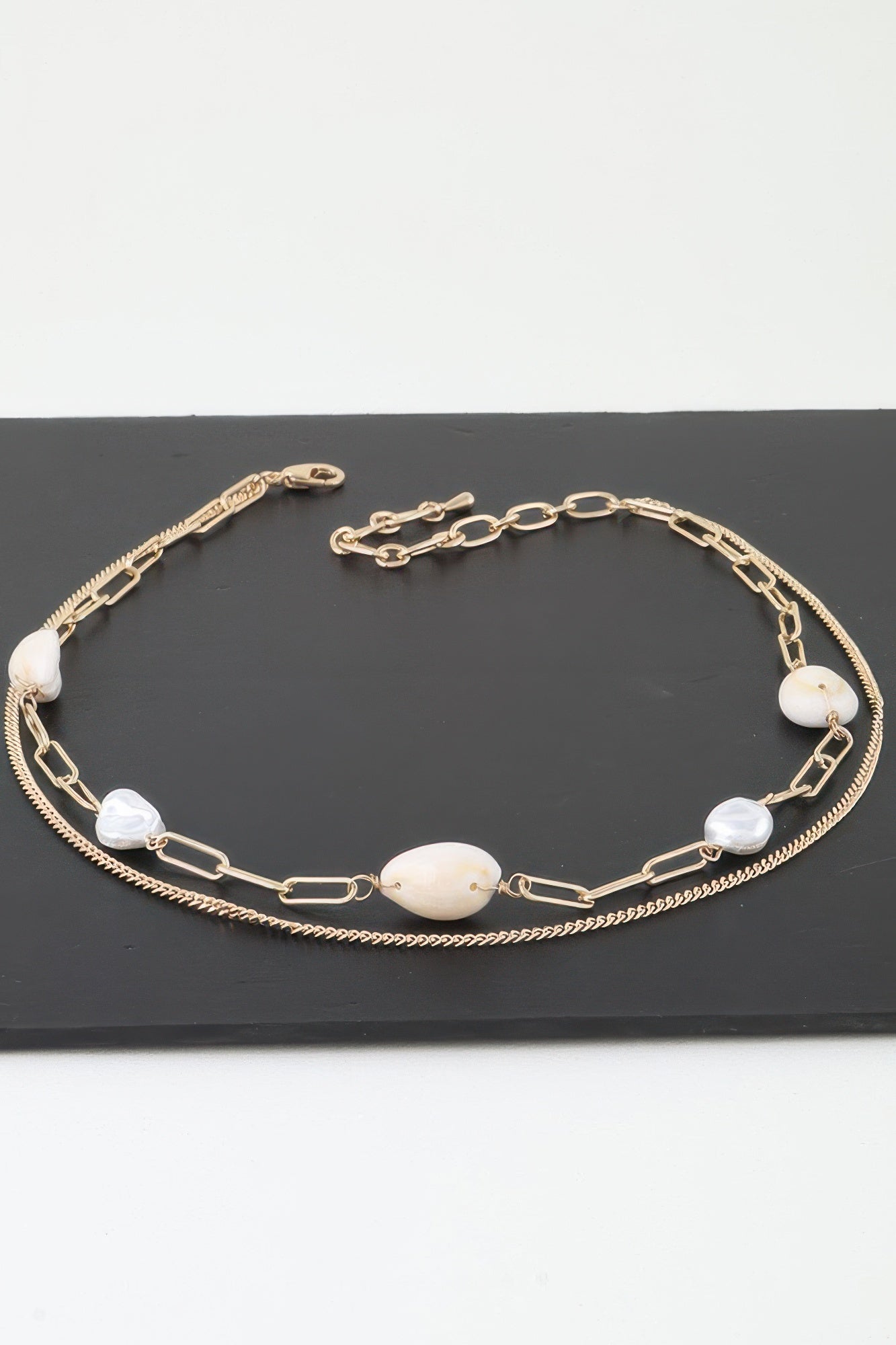 Gold double pearl chain necklace with oval cream pendants and small white beads