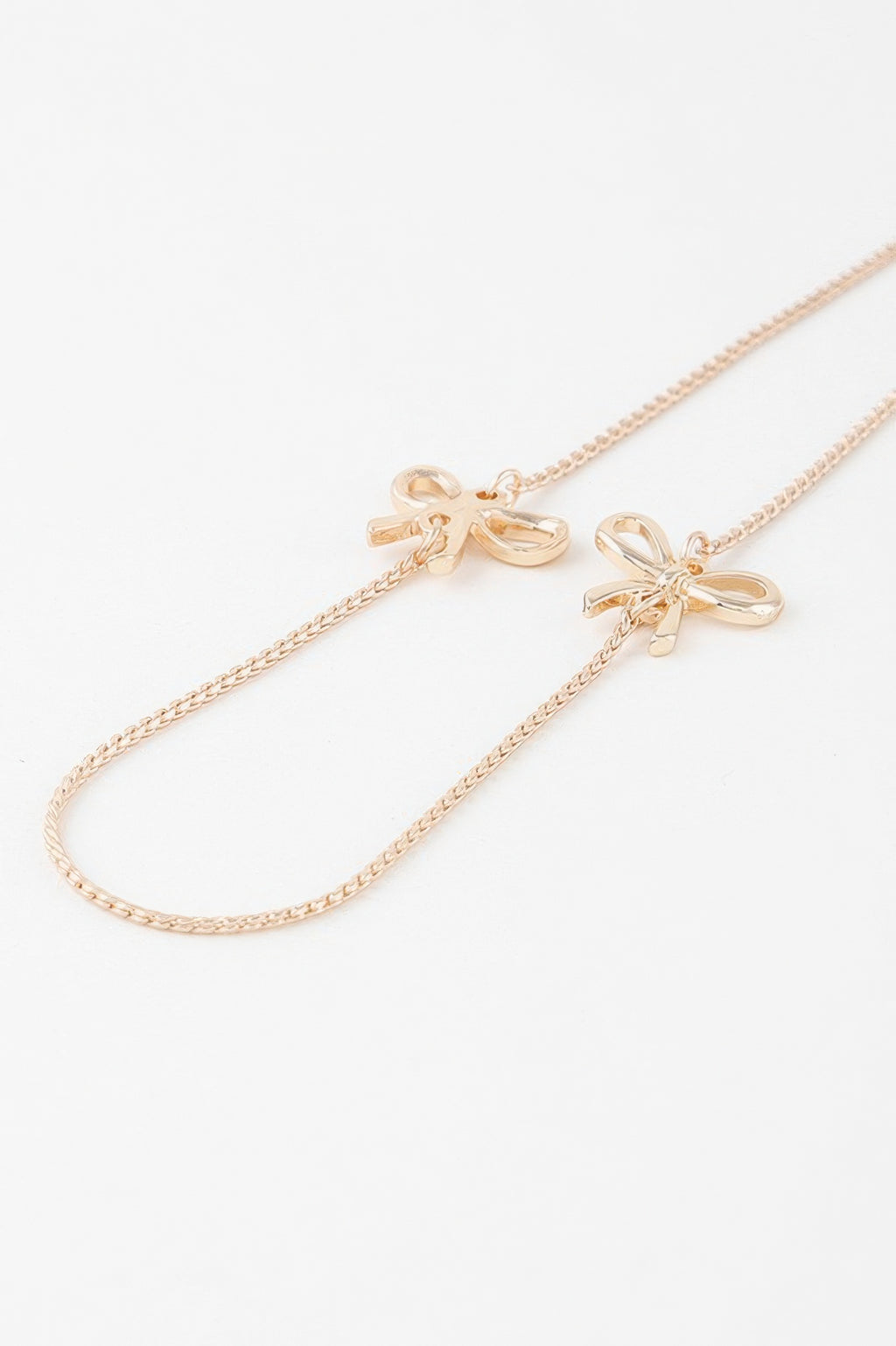 Gold double ribbon chain necklace with two bow charms, adjustable links