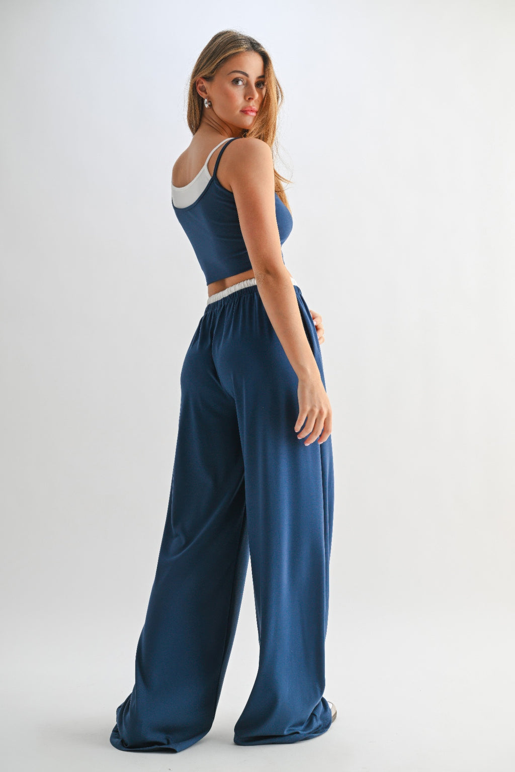 Back/side view of blue crop top and flowy drawstring lounge pants set with white trim