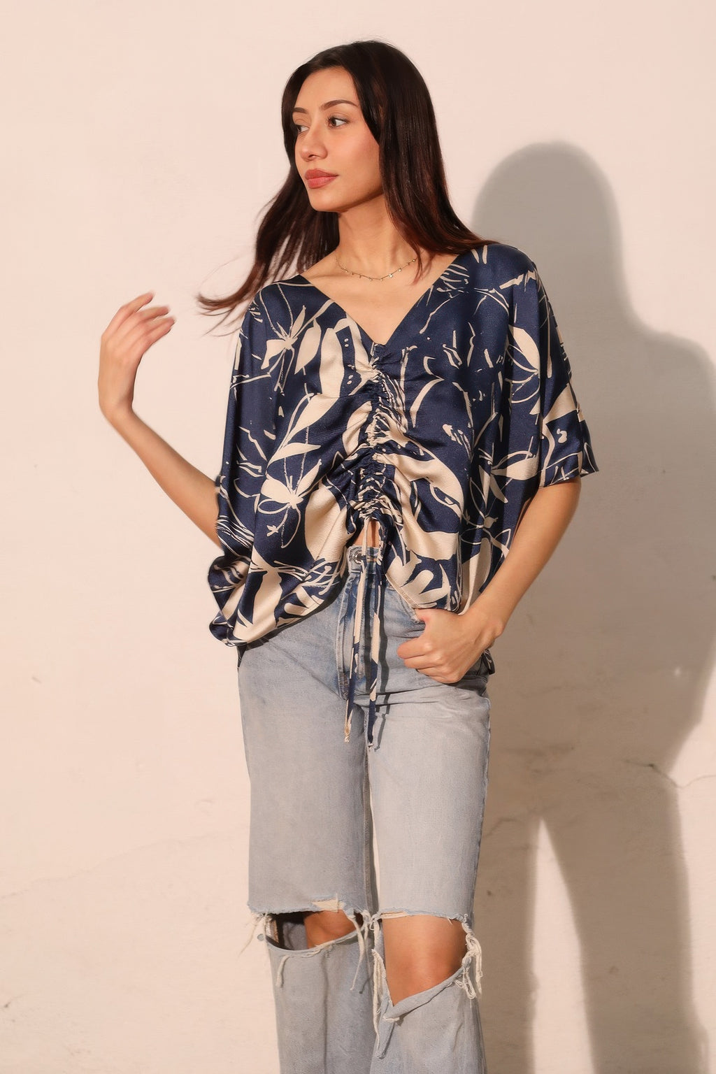 Navy satin dolman drawstring top with V-neck and ruched front, floral print.