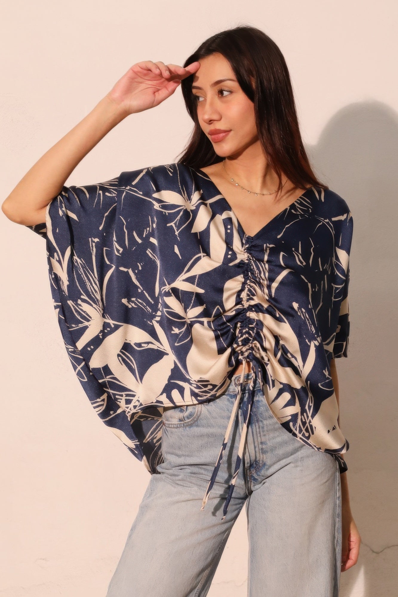 Navy satin dolman blouse with V-neck, gathered drawstring front, floral pattern.