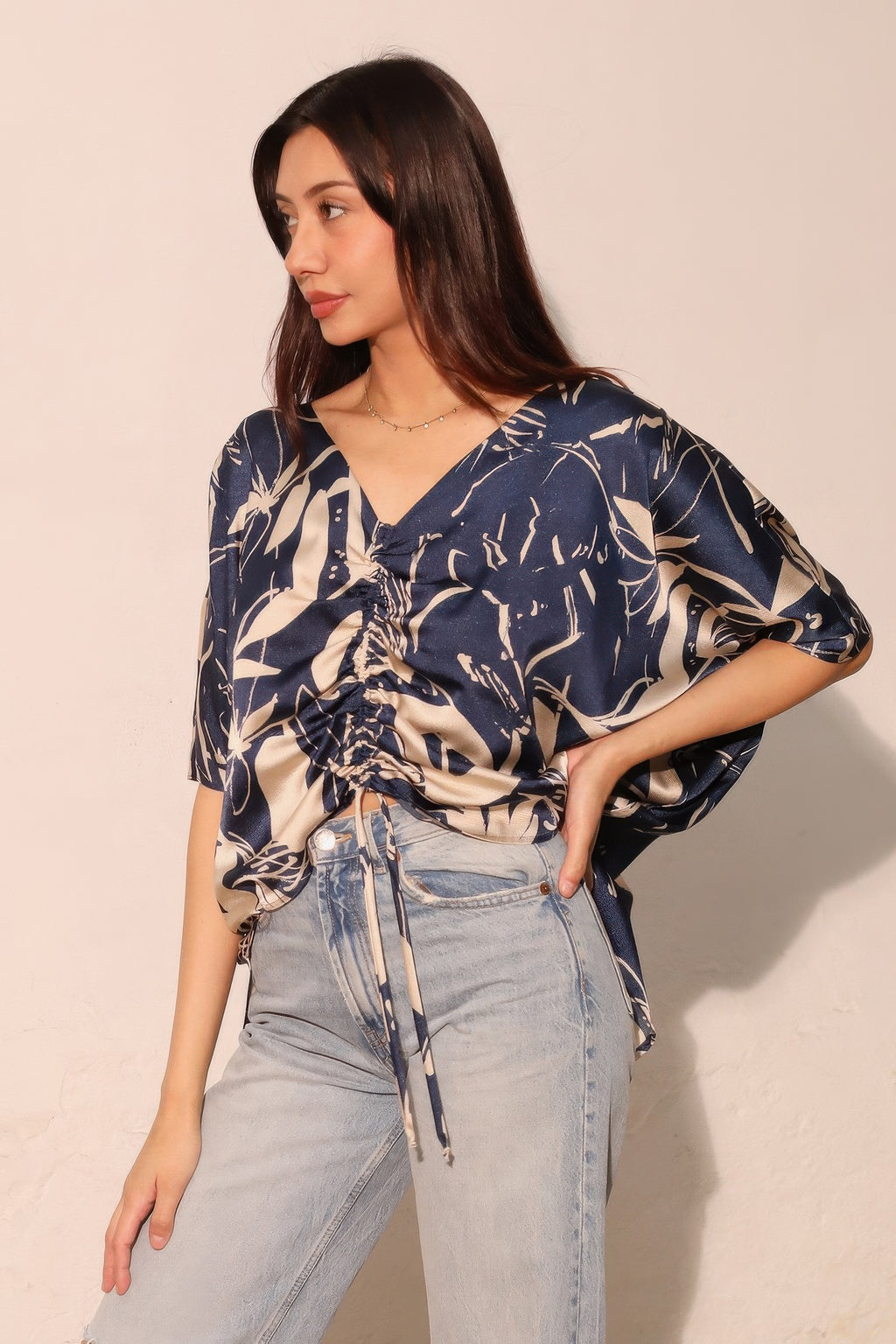 Navy satin drawstring dolman top, V-neck with tied ruching at center front.