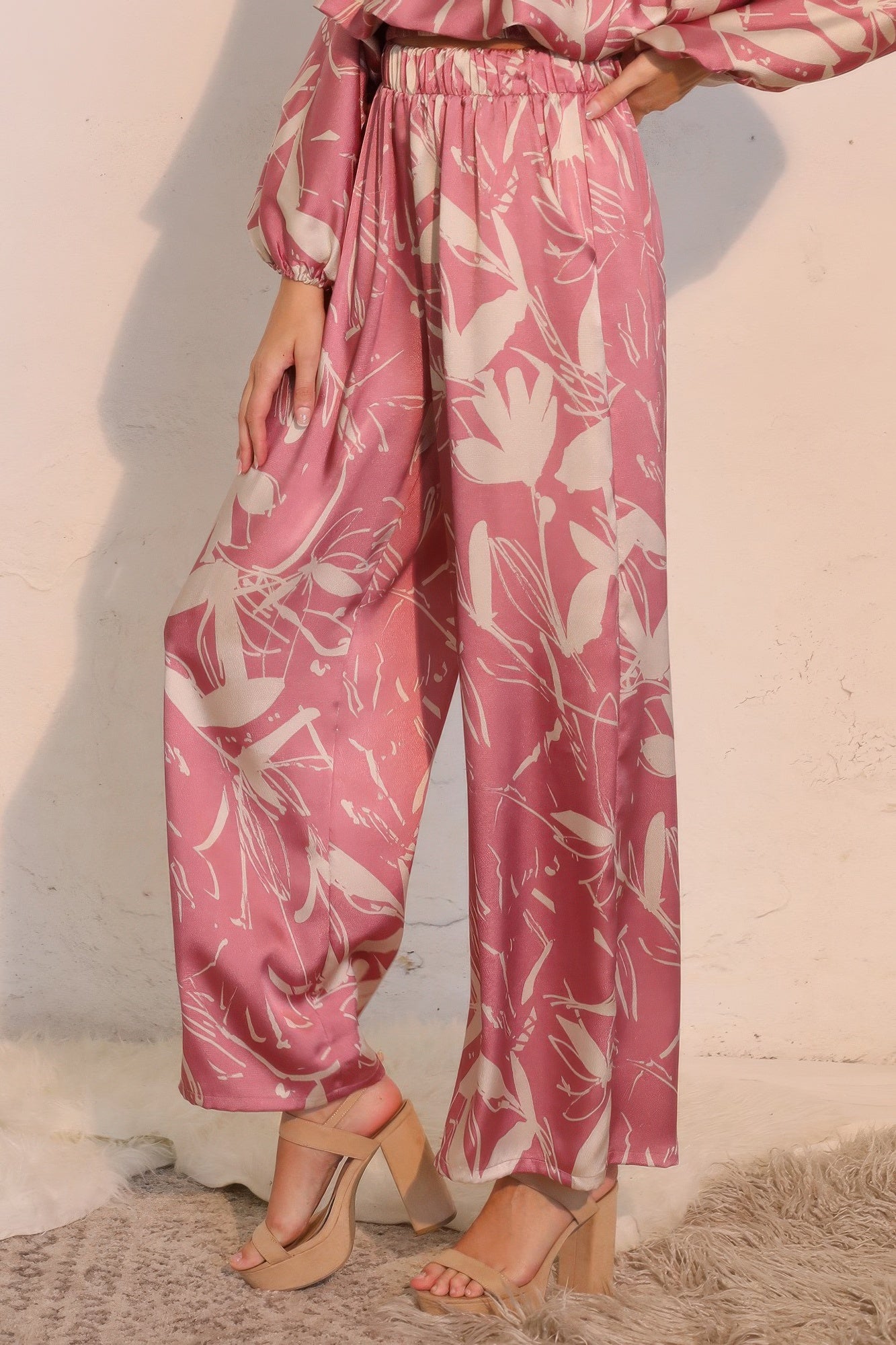 Pink satin wide-leg pants with botanical print, elastic waistband, side view