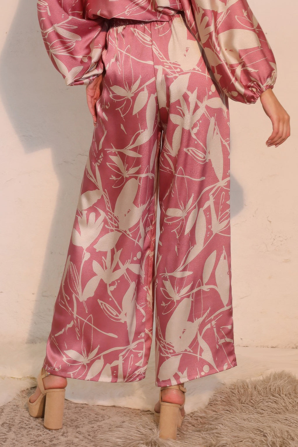 Pink satin wide-leg pants with gathered elastic waist and botanical print