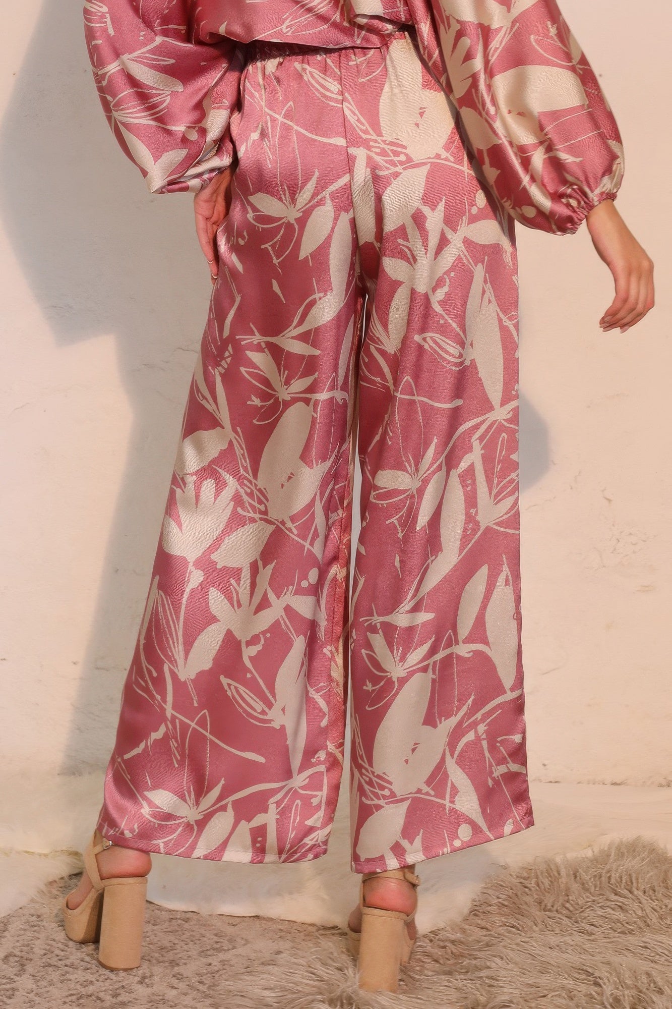 Pink satin wide-leg pants with gathered elastic waist and botanical print