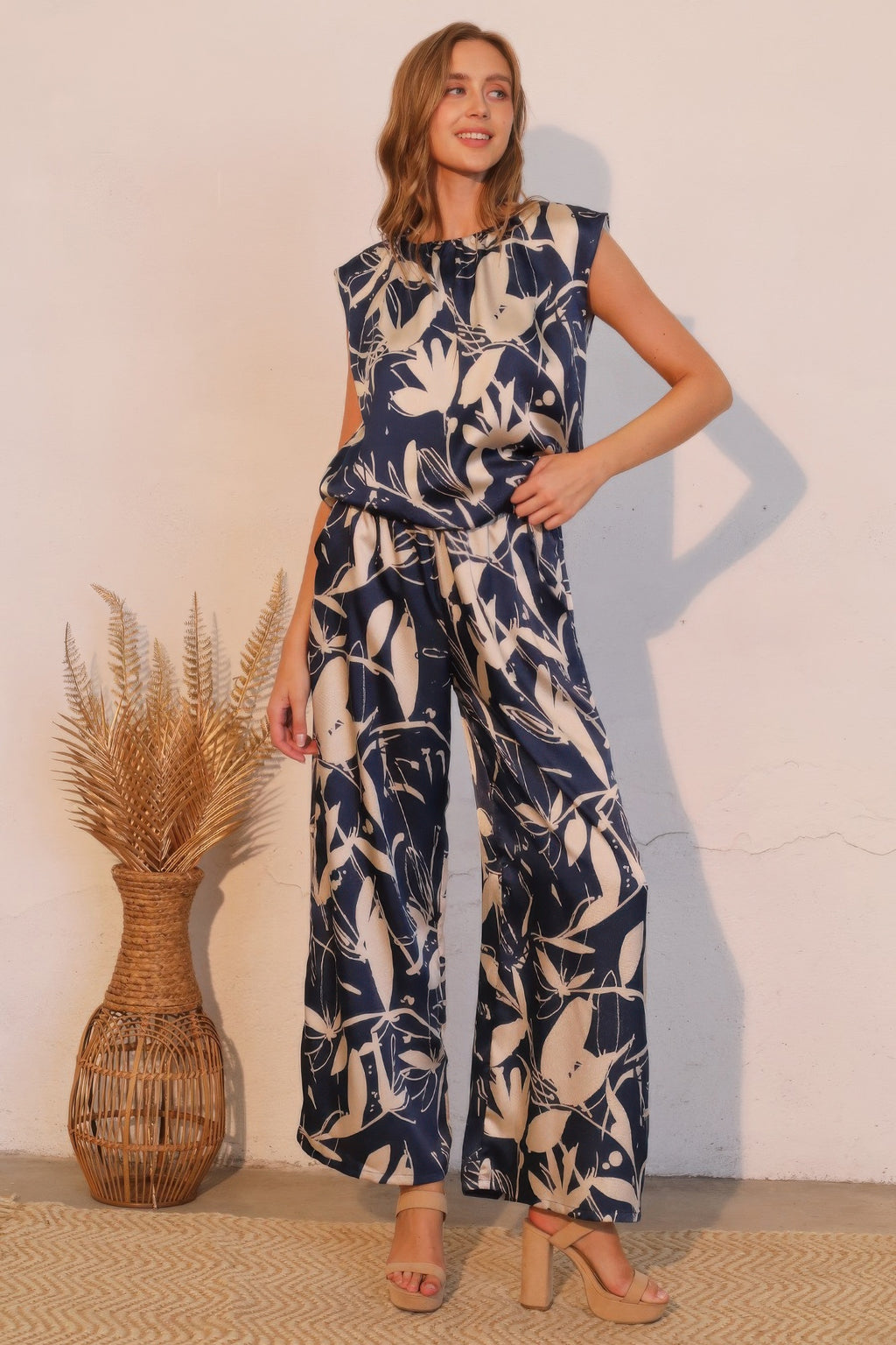 Navy satin wide-leg pants with cream botanical print, elastic waistband, full length