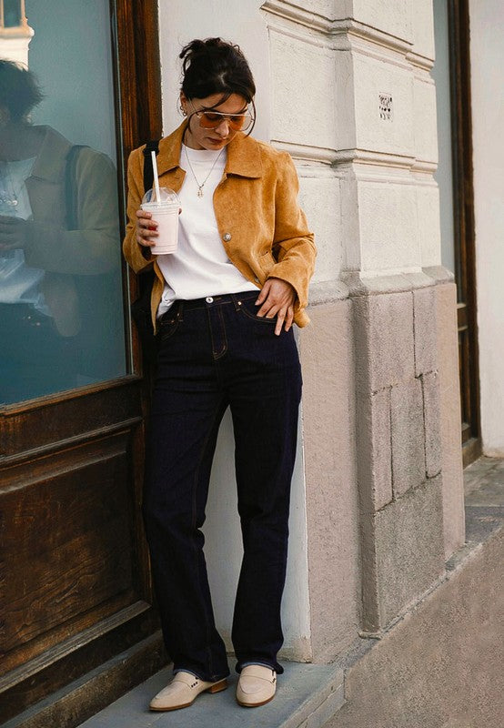 Sand suede loafers worn with jeans, featuring black square studs on the strap