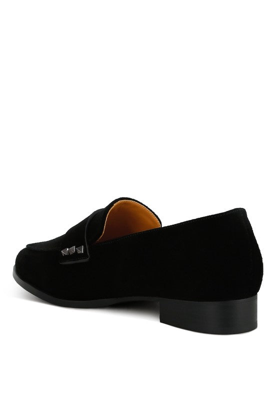 Black suede loafers from the side, showing strap with square stud accent