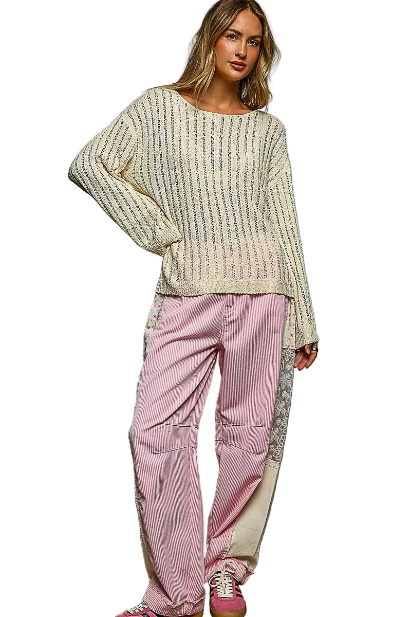 Tan open-knit long sleeve sweater with round neck, draped fit over pants