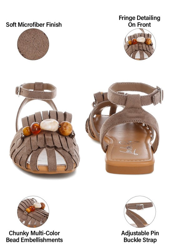 Taupe flat sandal close-up: fringe front, chunky multi-color beads, and adjustable strap